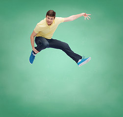 Image showing smiling young man jumping in air