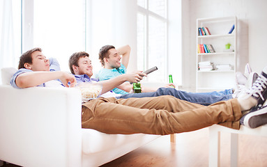 Image showing happy male friends with beer watching tv at home