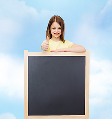 Image showing happy little girl with blank blackboard