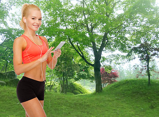 Image showing smiling sporty woman with smartphone and earphones