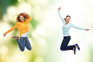 Image showing smiling young women jumping in air