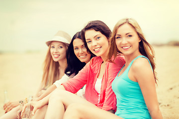 Image showing smiling girls with drinks on the beach