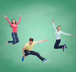 Image showing group of smiling teenagers jumping in air