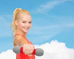 Image showing smiling beautiful sporty woman with dumbbell