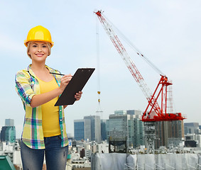 Image showing smiling woman in helmet with clipboard