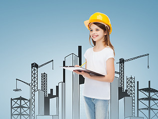 Image showing smiling little girl in hardhat with clipboard