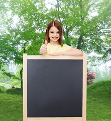 Image showing happy little girl with blank blackboard