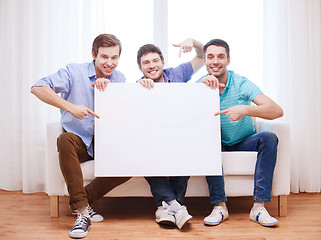 Image showing happy male friends with blank white board at home