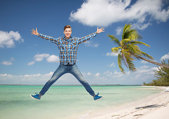 Image showing smiling young man jumping in air