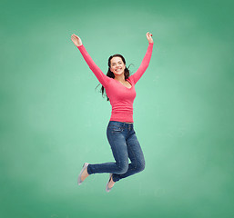 Image showing smiling young woman jumping in air