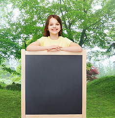 Image showing happy little girl with blank blackboard