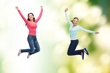 Image showing smiling young women jumping in air