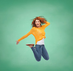 Image showing smiling young woman jumping in air