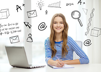 Image showing smiling teenage girl laptop computer and notebook