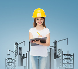 Image showing smiling little girl in hardhat with clipboard