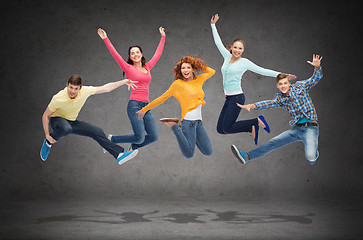 Image showing group of smiling teenagers jumping in air