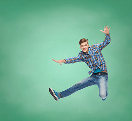 Image showing smiling young man jumping in air