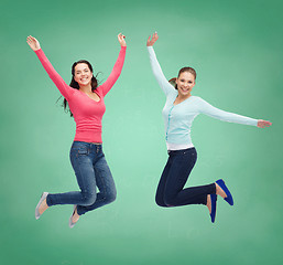 Image showing smiling young women jumping in air