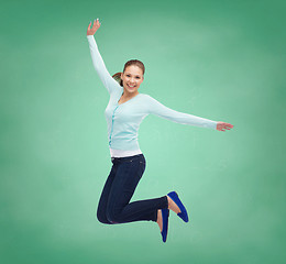 Image showing smiling young woman jumping in air