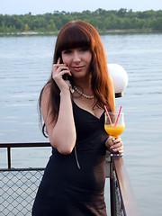 Image showing The girl with a cocktail speaks to mobile phone2