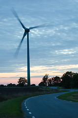 Image showing Wind turbine at winding road in a rural landscape