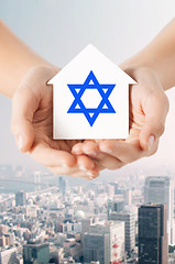 Image showing close up of hands holding house with star of david