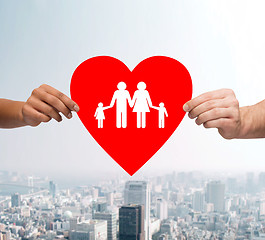 Image showing couple hands holding red heart with family