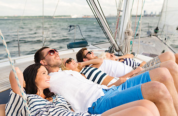 Image showing smiling friends lying on yacht deck