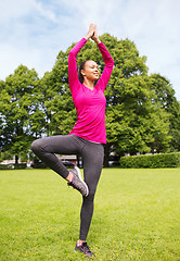 Image showing smiling african american woman exercising outdoors