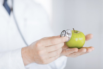 Image showing male doctor with green apple and stethoscope