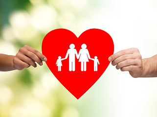 Image showing closeup of hands holding red heart with family