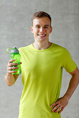 Image showing smiling man with bottle of water in gym