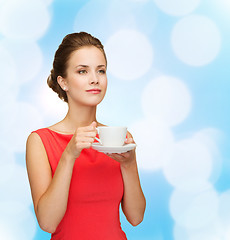 Image showing smiling woman in red dress with cup of coffee