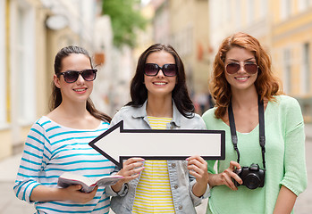 Image showing smiling teenage girls with white arrow outdoors