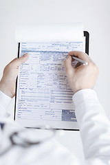 Image showing male doctor holding prescription paper in hand