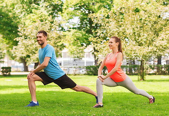 Image showing smiling couple stretching outdoors