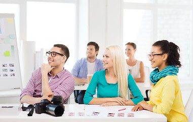 Image showing smiling team with photocamera working in office