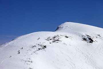 Image showing Snowboarders and skiers downhill on off piste slope at sun day