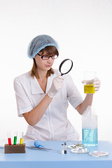 Image showing Chemist looking at the liquid in flask