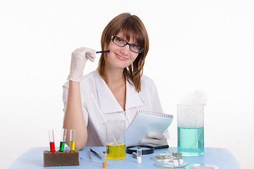 Image showing Chemistry teacher takes notes in notepad