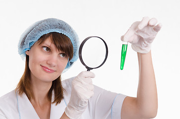 Image showing Chemist examines liquid in a test tube