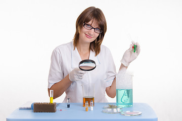 Image showing Chemist examines the contents of flask
