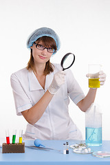 Image showing Chemistry teacher looking at liquid in flask