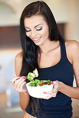 Image showing Young woman eating a healthy fresh salad