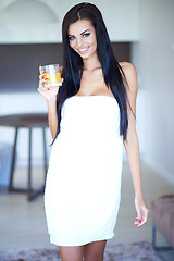 Image showing Young woman enjoying a glass of fresh orange