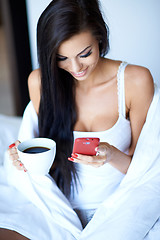 Image showing Young woman texting on her mobile phone