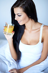 Image showing Young woman enjoying a glass of orange juice