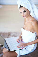 Image showing Woman Wearing Bath Towel Using Laptop Computer