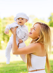 Image showing happy mother with little baby sitting on blanket