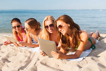 Image showing group of smiling young women with tablets on beach